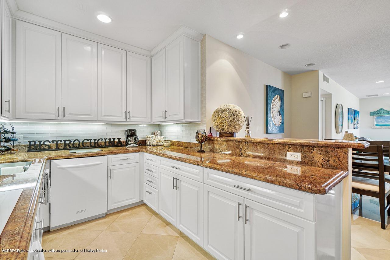 5900 Old Ocean Boulevard, Unit B1 Ocean Ridge, FL 33435 - Photo 11 of 26 a kitchen with granite countertop a sink white cabinets and white appliances
