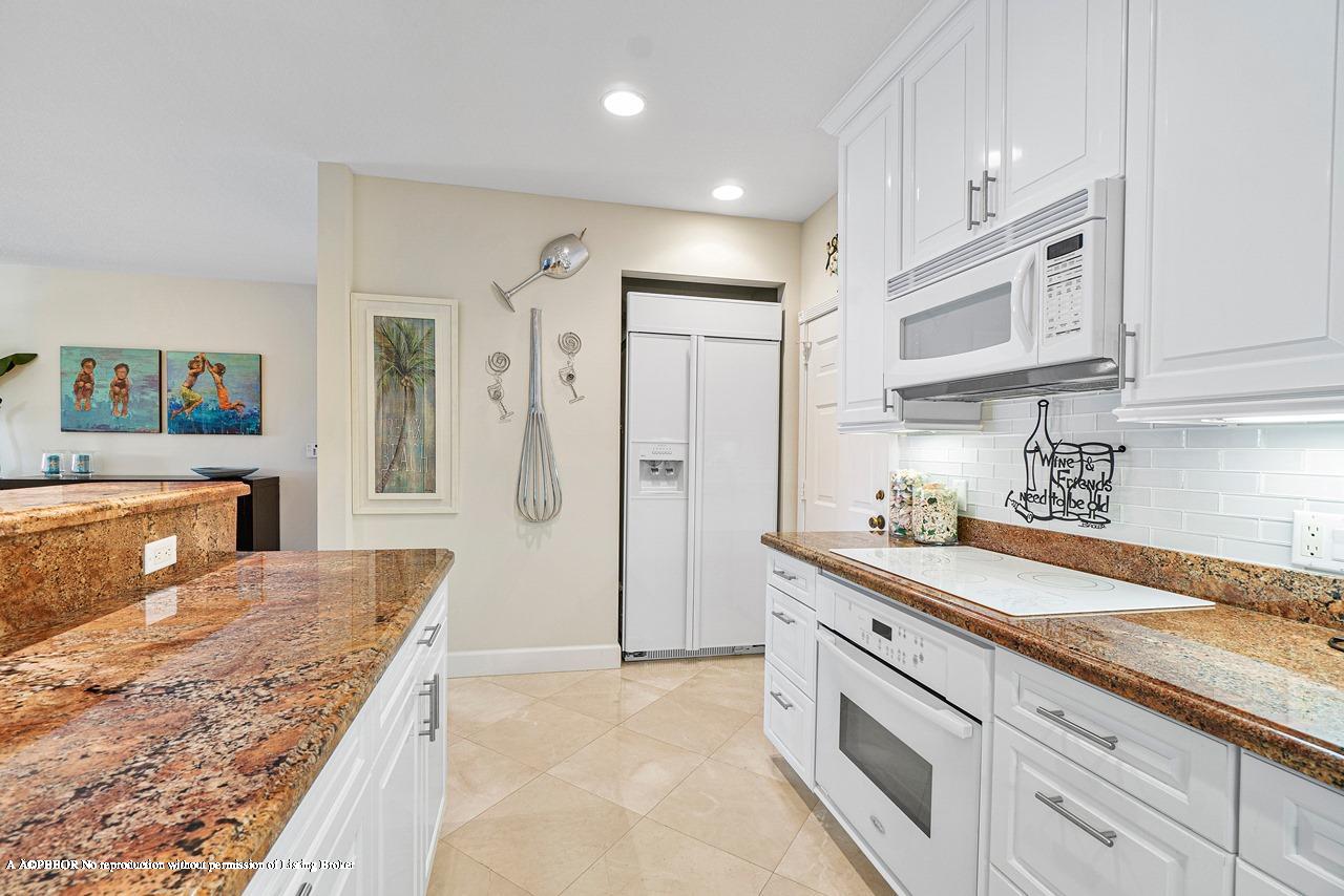5900 Old Ocean Boulevard, Unit B1 Ocean Ridge, FL 33435 - Photo 12 of 26 a large kitchen with stainless steel appliances granite countertop a lot of counter space and wooden floor