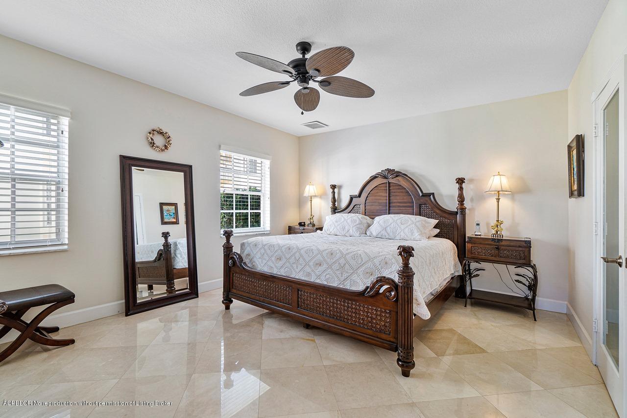 5900 Old Ocean Boulevard, Unit B1 Ocean Ridge, FL 33435 - Photo 14 of 26 a bedroom with a bed and a chandelier