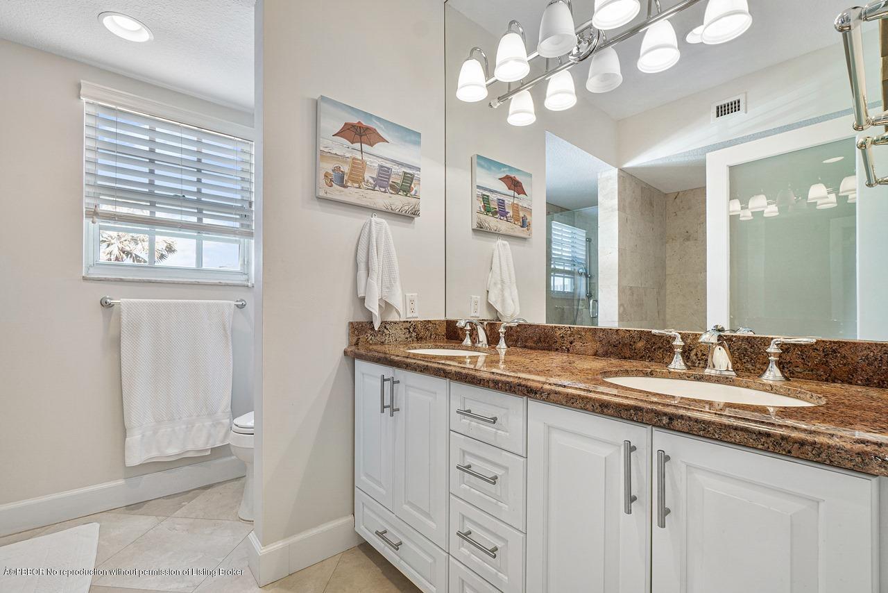 5900 Old Ocean Boulevard, Unit B1 Ocean Ridge, FL 33435 - Photo 15 of 26 a bathroom with a granite countertop double vanity sink a mirror and a bathtub