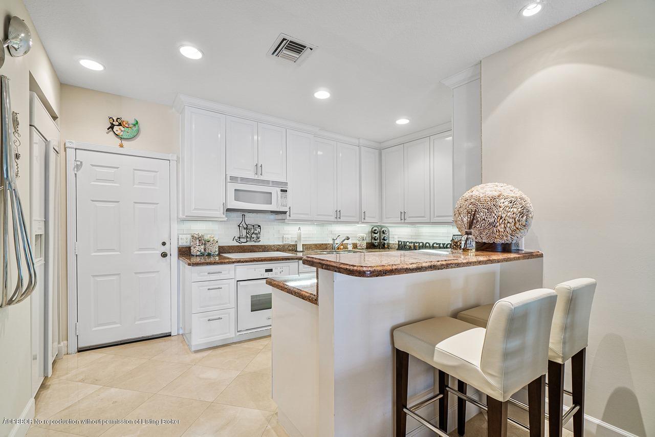 5900 Old Ocean Boulevard, Unit B1 Ocean Ridge, FL 33435 - Photo 9 of 26 a kitchen with kitchen island granite countertop a sink and stove
