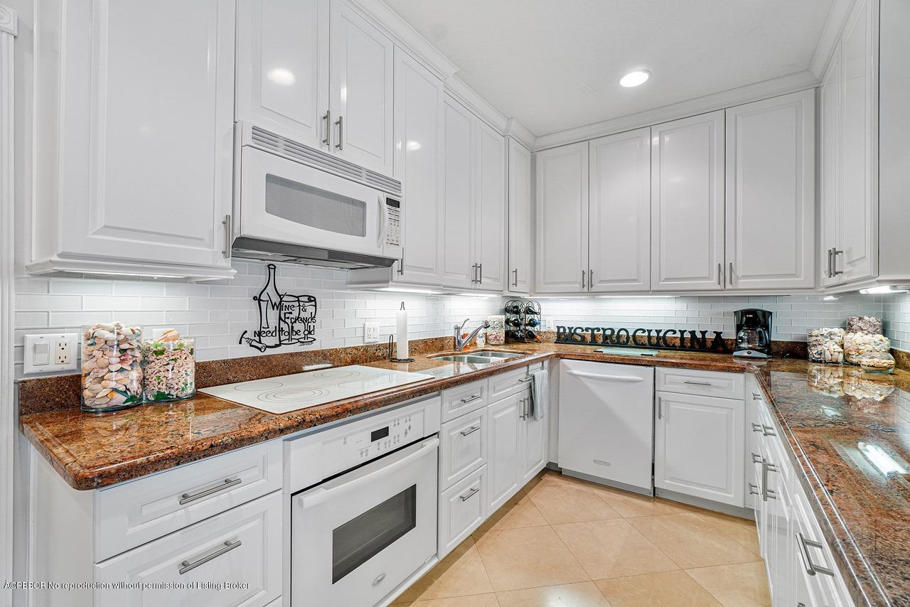 5900 Old Ocean Boulevard, Unit B1 Ocean Ridge, FL 33435 - Photo 10 of 26 a kitchen with granite countertop white cabinets stainless steel appliances and a counter space