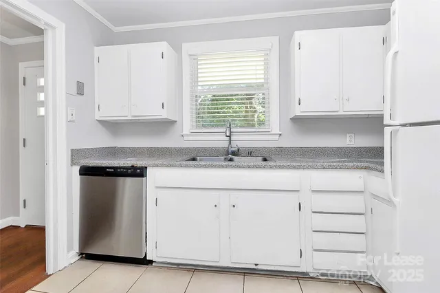 a kitchen with granite countertop white cabinets and a sink