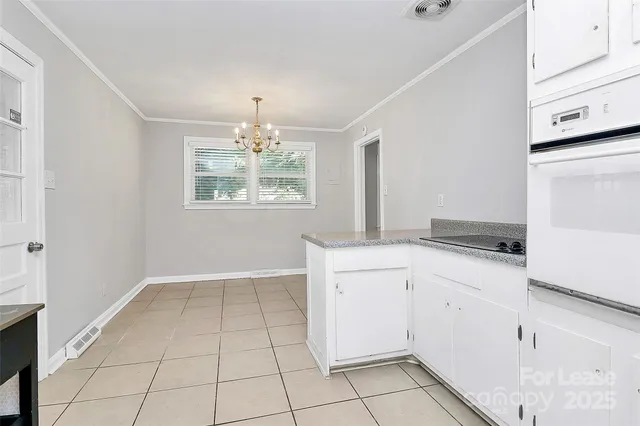 a kitchen with granite countertop white cabinets and white appliances