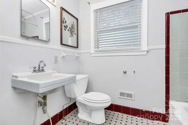 a bathroom with a sink a toilet and mirror