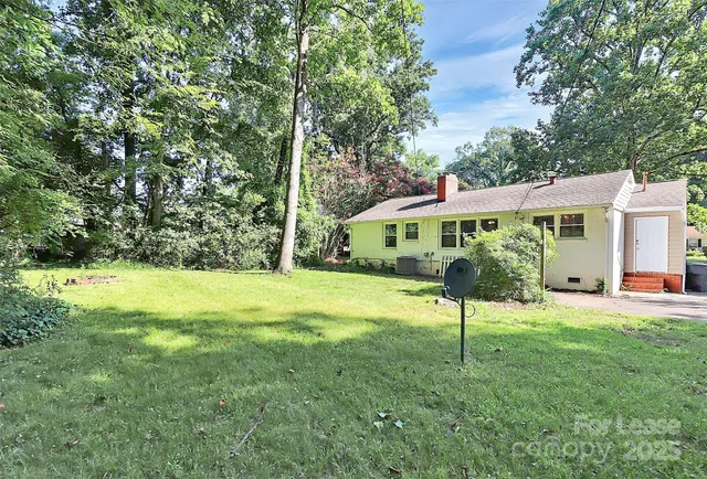 a view of an house with backyard and a tree