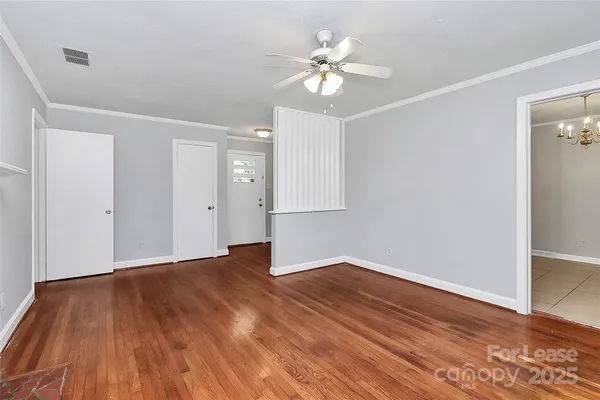 a view of an empty room with wooden floor