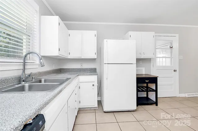 a kitchen with a refrigerator a stove and a sink