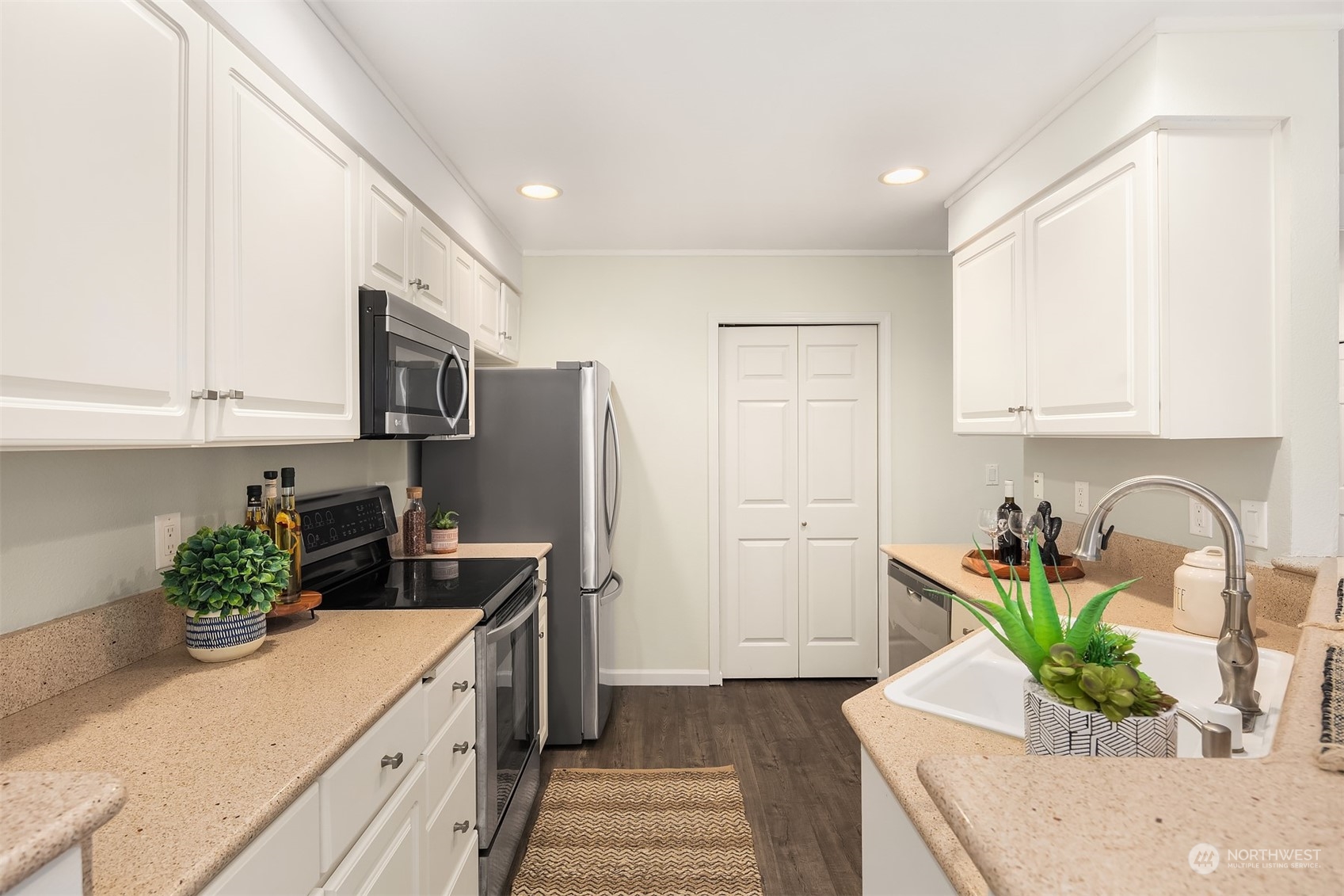18710 20th Avenue Southeast Bothell, WA 98012 - Photo 25 of 40 a kitchen with stainless steel appliances kitchen island granite countertop a refrigerator a stove a sink dishwasher and white cabinets with wooden floor