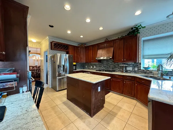 a kitchen with stainless steel appliances granite countertop a refrigerator and a sink