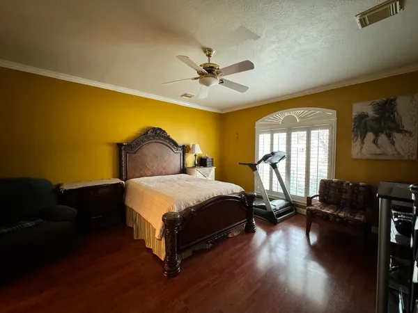 a bedroom with a bed and a flat tv screen on dresser
