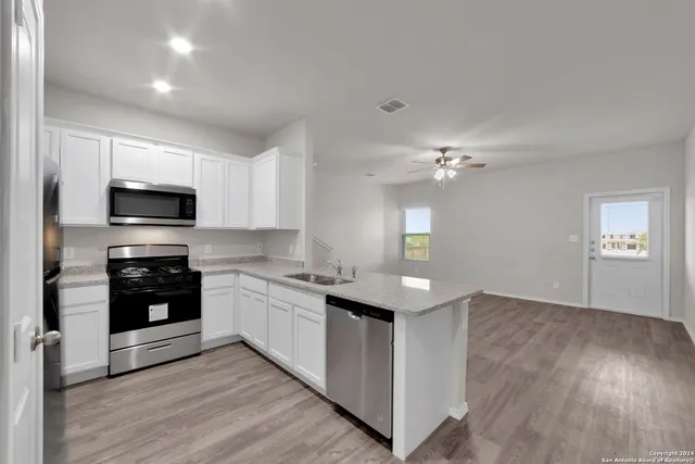 a kitchen with a sink and steel appliances