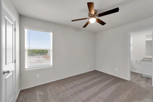 a view of empty room with ceiling fan
