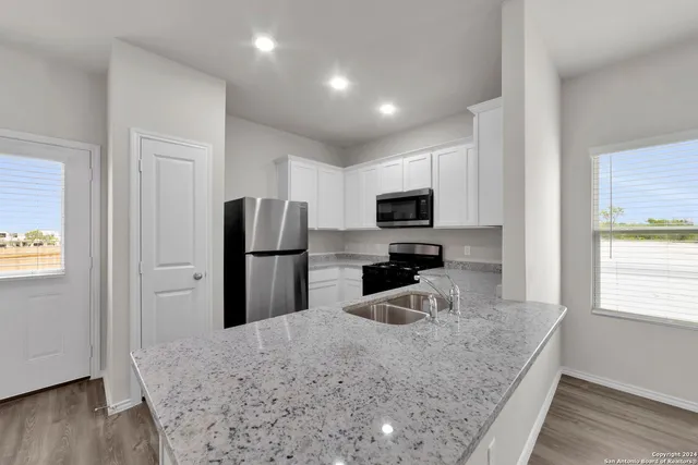 a kitchen with refrigerator cabinets and wooden floor