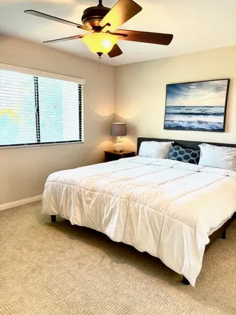 a bedroom with a bed and painting on the wall