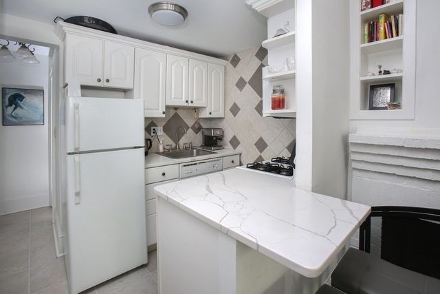 a kitchen with stainless steel appliances a refrigerator sink and cabinets
