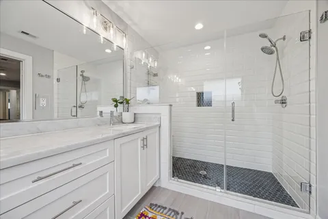 a bathroom with a shower sink and mirror