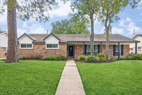 a front view of a house with a yard and garden