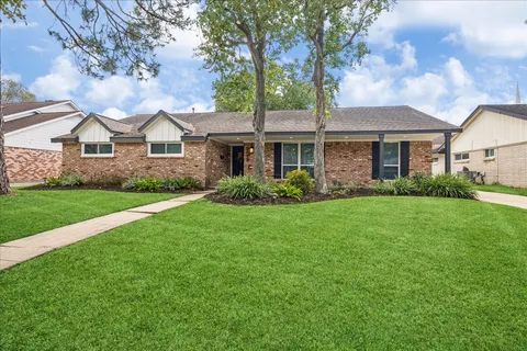 a front view of a house with a garden and yard