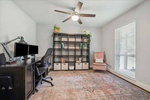 a view of a workspace with furniture and a window