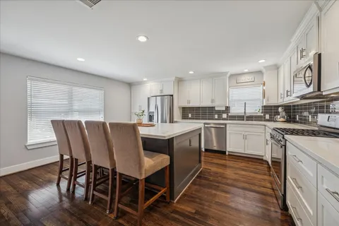 a kitchen with a table chairs sink microwave and cabinets