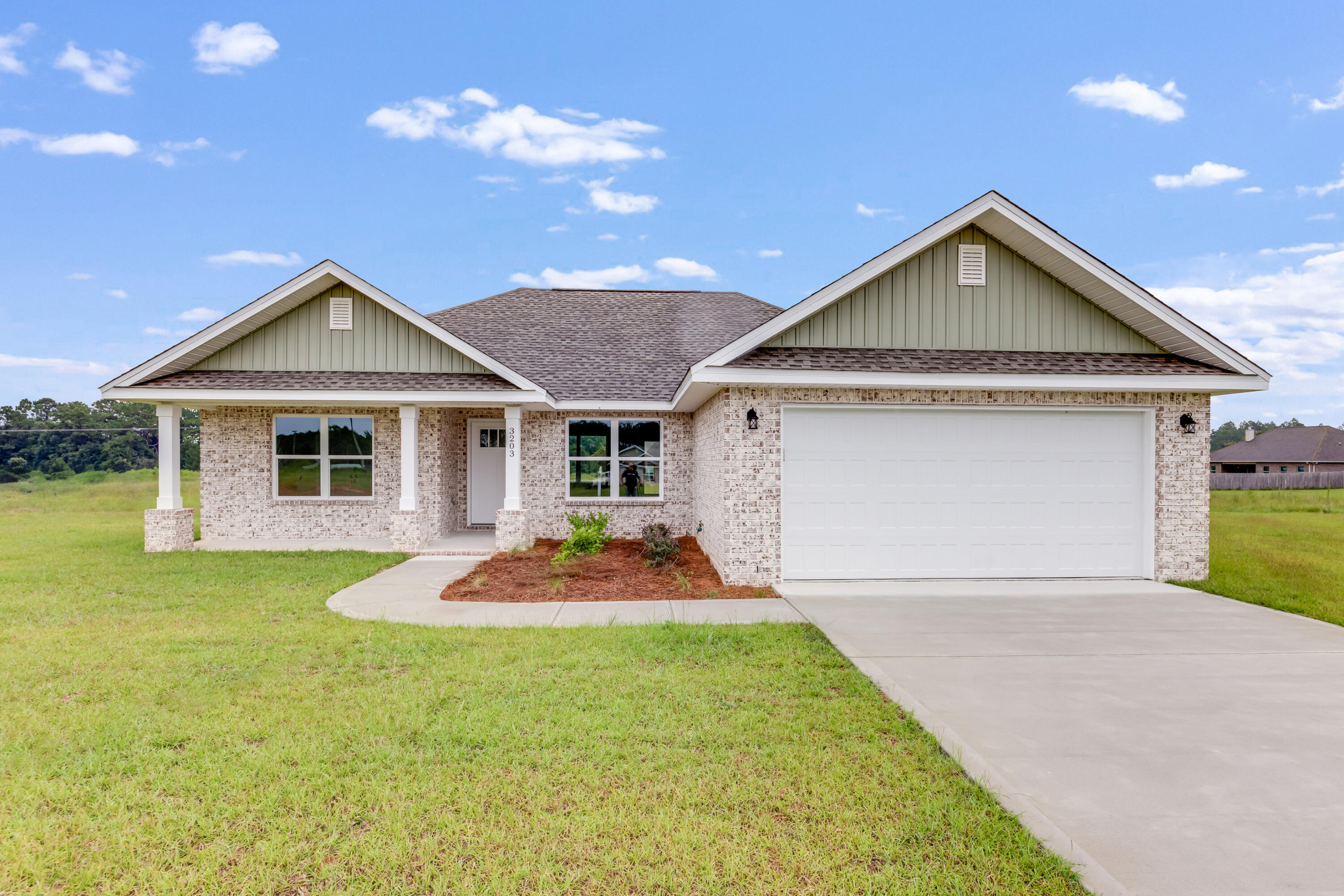a front view of a house with yard and green space