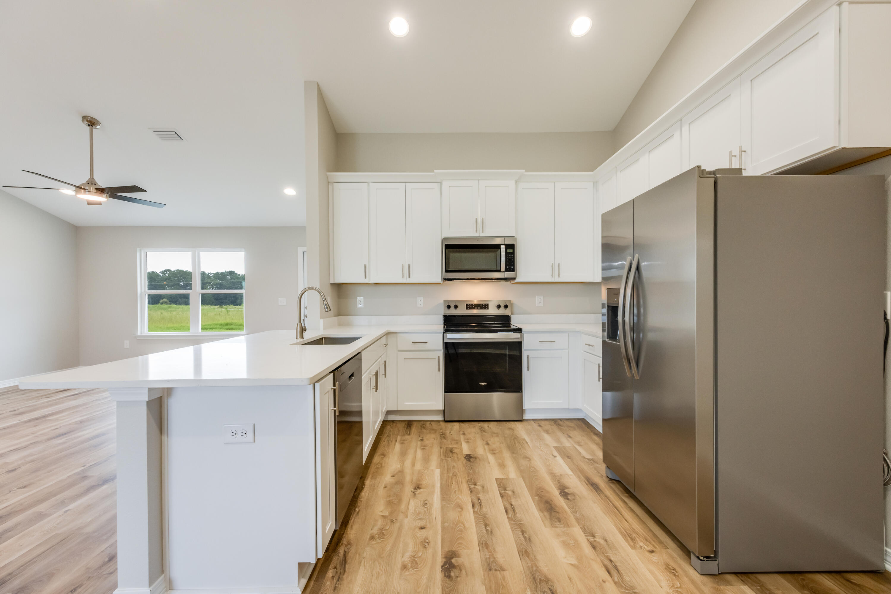 3203 Liz Court Crestview, FL 32539 - Photo 11 of 35 a kitchen with a refrigerator a sink dishwasher with a oven and a refrigerator with wooden floor