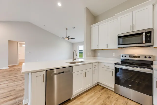 a kitchen with stainless steel appliances a stove microwave and sink