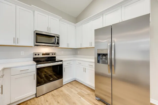 a kitchen with cabinets stainless steel appliances and a counter space