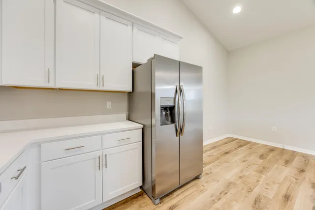 a kitchen with white cabinets and white appliances