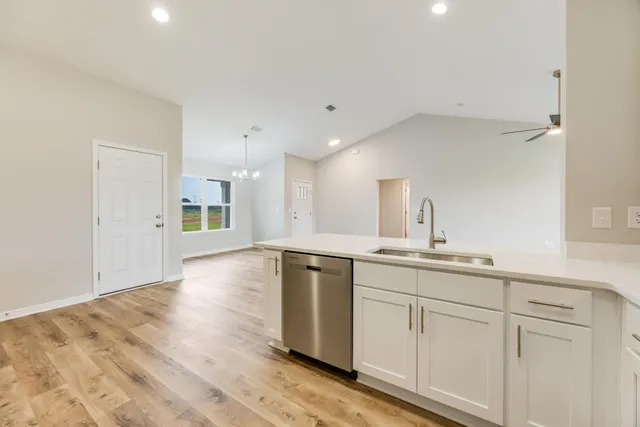 a kitchen with a sink cabinets and wooden floor