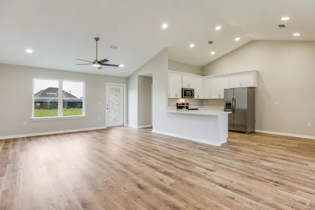 a view of kitchen with refrigerator microwave and cabinets