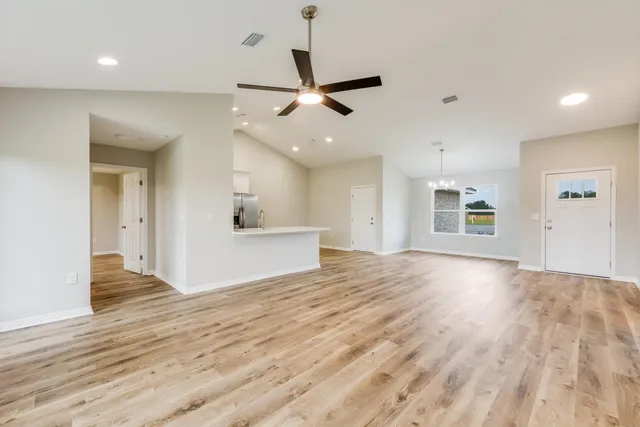 a view of an empty room and kitchen view