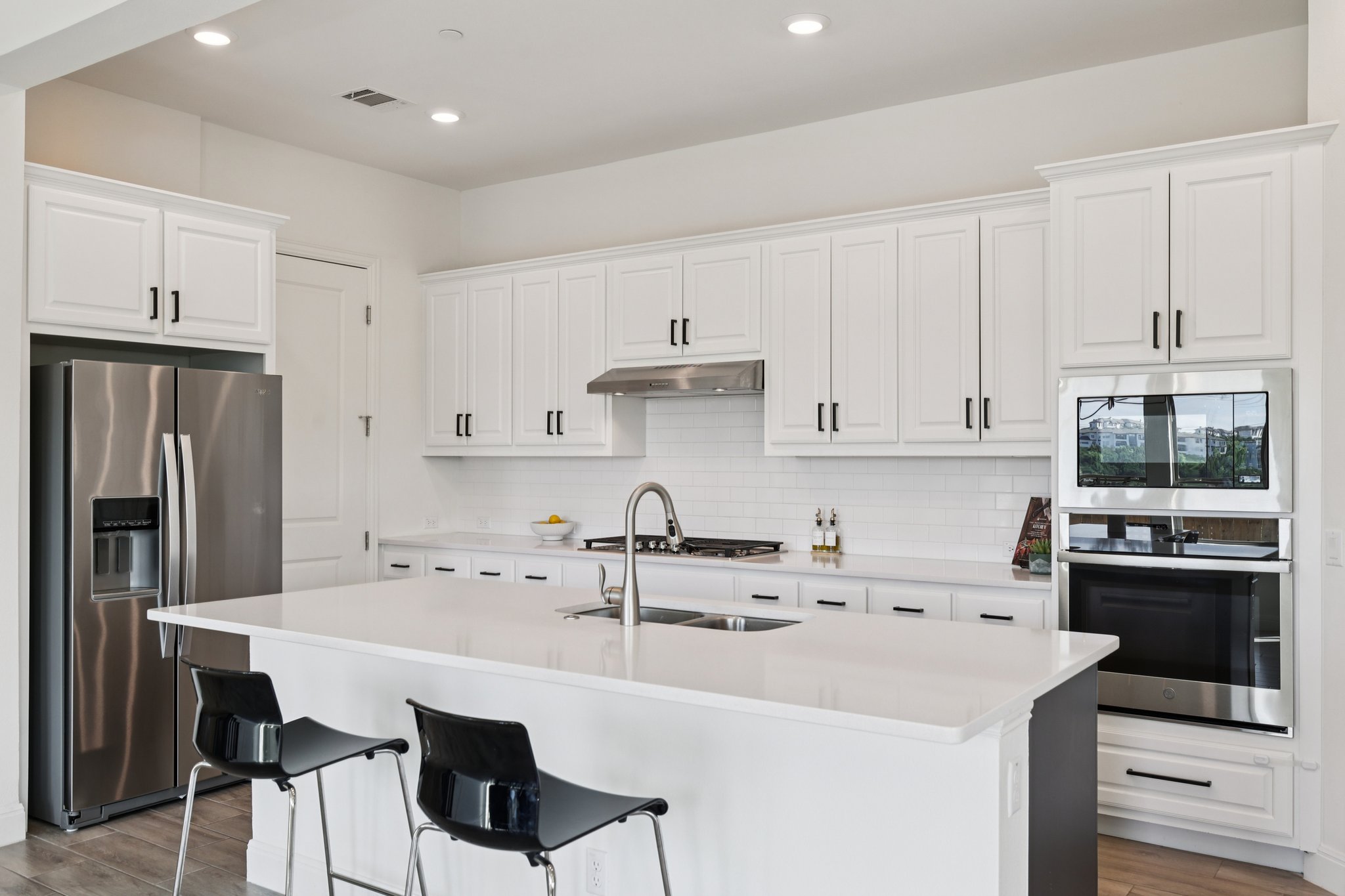 12500 Simmental Drive Austin, TX 78732 - Photo 2 of 31 a kitchen with stainless steel appliances a stove a sink a refrigerator and cabinets