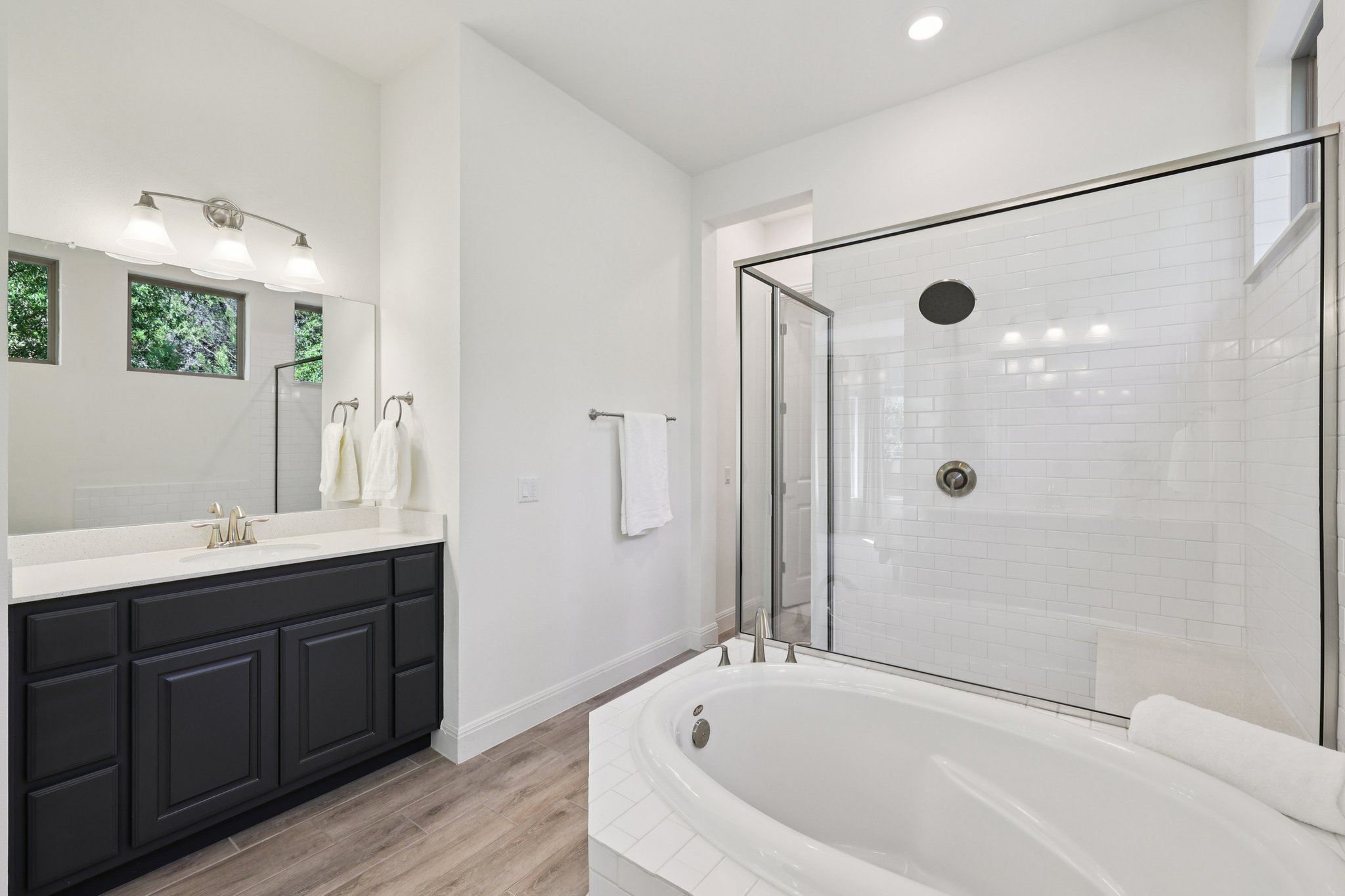12500 Simmental Drive Austin, TX 78732 - Photo 8 of 31 a bathroom with a bathtub a mirror a shower and vanity