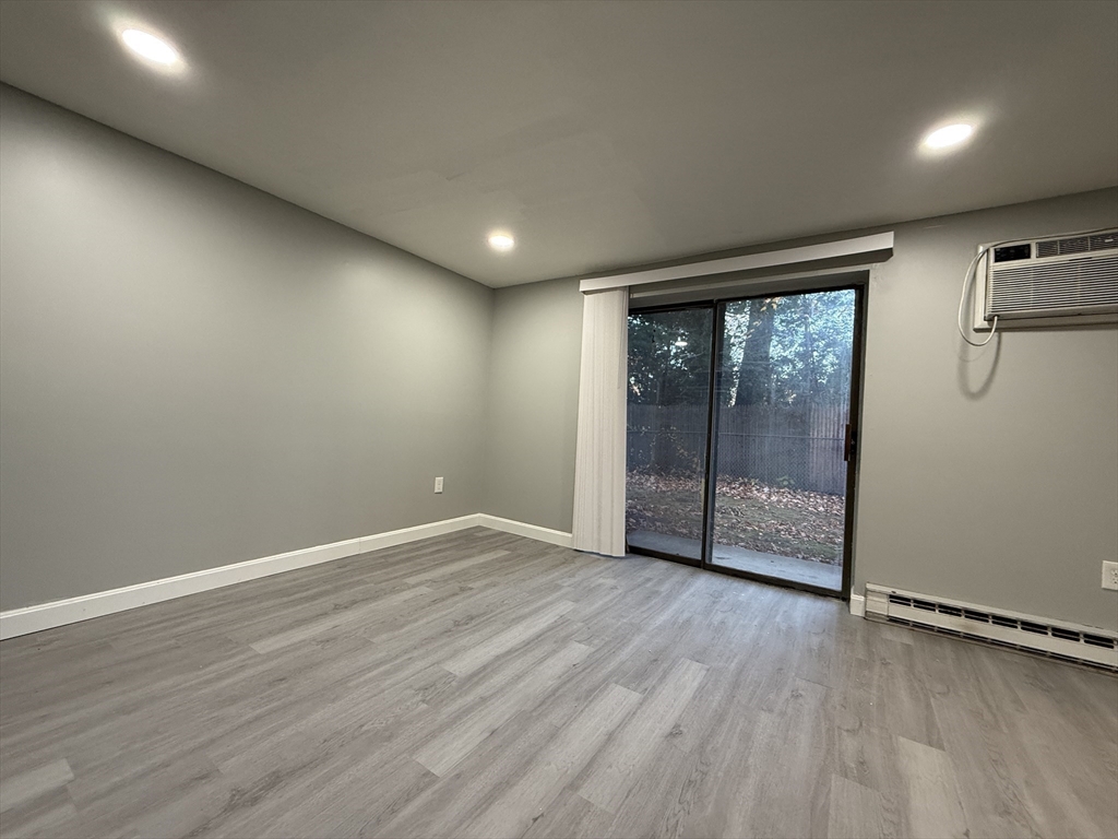 1186 Worcester Road, Unit 610 Framingham, MA 01702 - Photo 12 of 37 a view of an empty room with wooden floor and a window