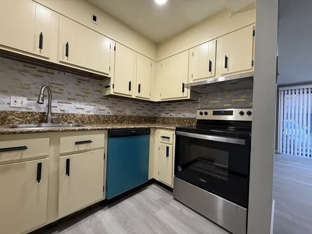 a kitchen with granite countertop white cabinets and appliances