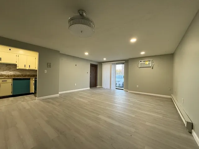 an empty room with wooden floor and a fireplace