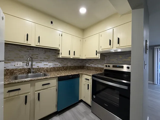 a kitchen with stainless steel appliances granite countertop a sink stove and cabinets