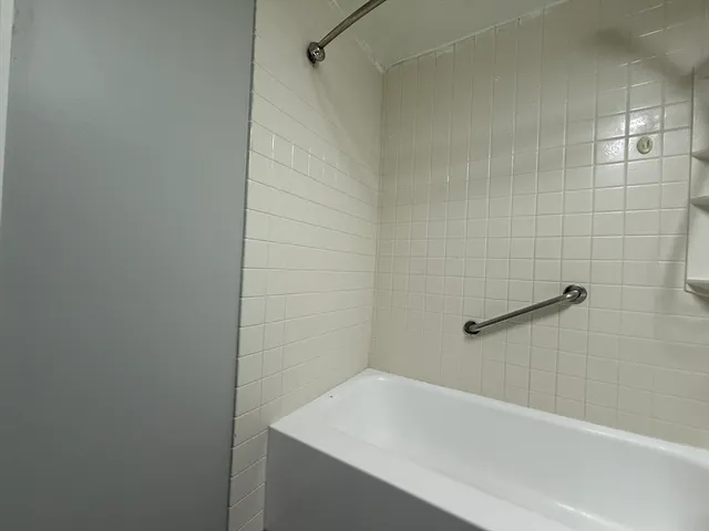 a bathroom with a white bath tub and a shower