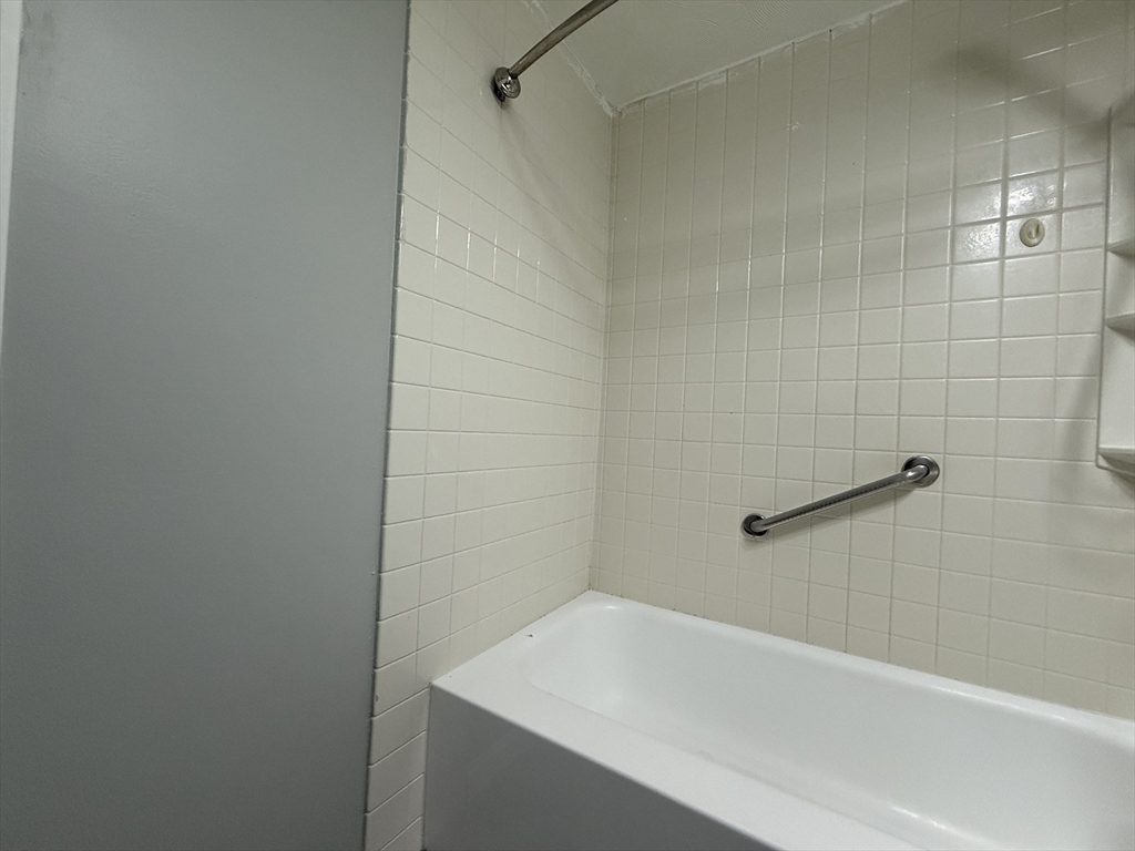 1186 Worcester Road, Unit 610 Framingham, MA 01702 - Photo 23 of 37 a bathroom with a white bath tub and a shower