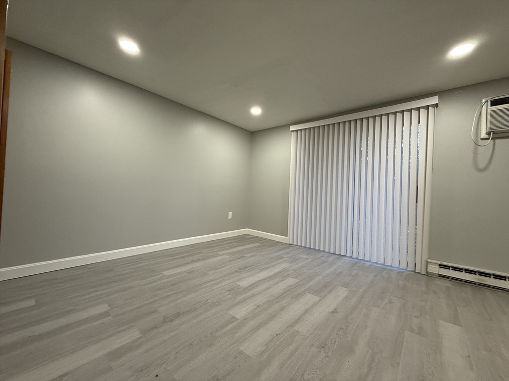 1186 Worcester Road, Unit 610 Framingham, MA 01702 - Photo 24 of 37 an empty room with wooden floor and windows