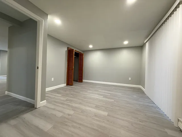 a view of an empty room with wooden floor