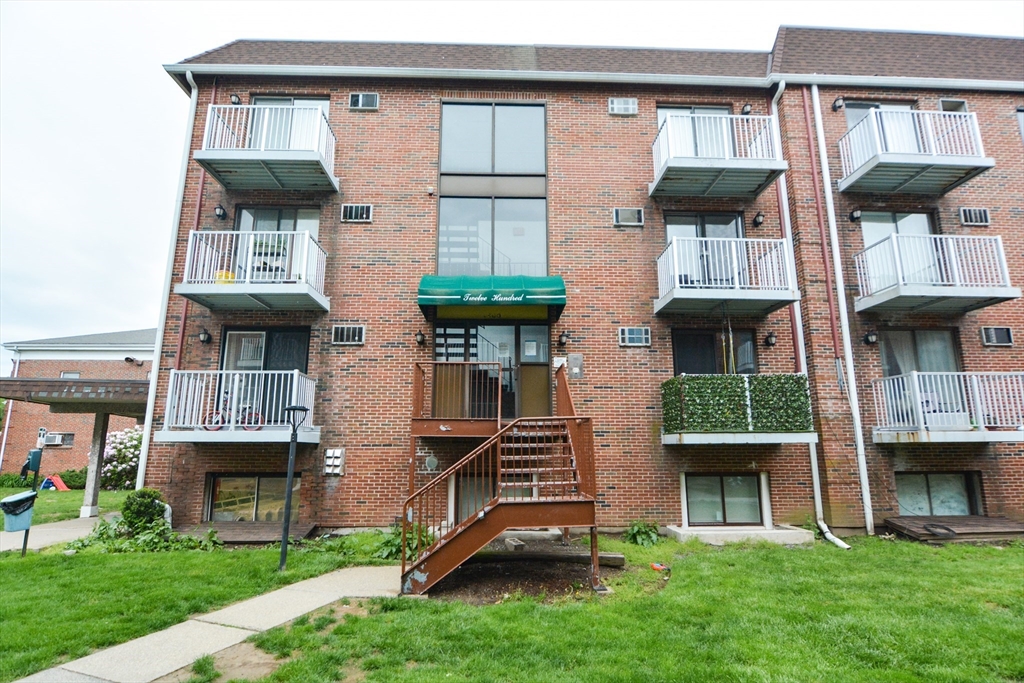 1186 Worcester Road, Unit 610 Framingham, MA 01702 - Photo 33 of 37 a front view of a house with a garden and plants