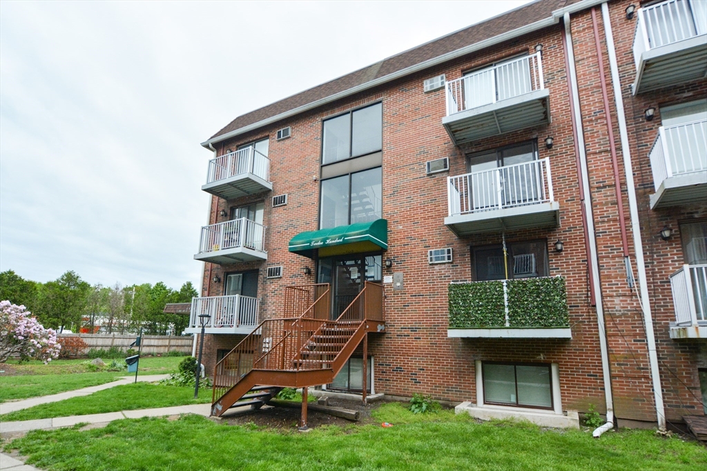 1186 Worcester Road, Unit 610 Framingham, MA 01702 - Photo 34 of 37 a front view of a house with garden and plants
