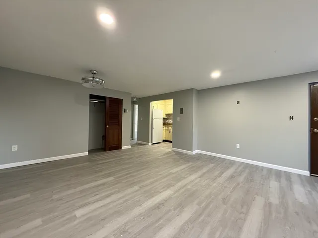 an empty room with closet and windows