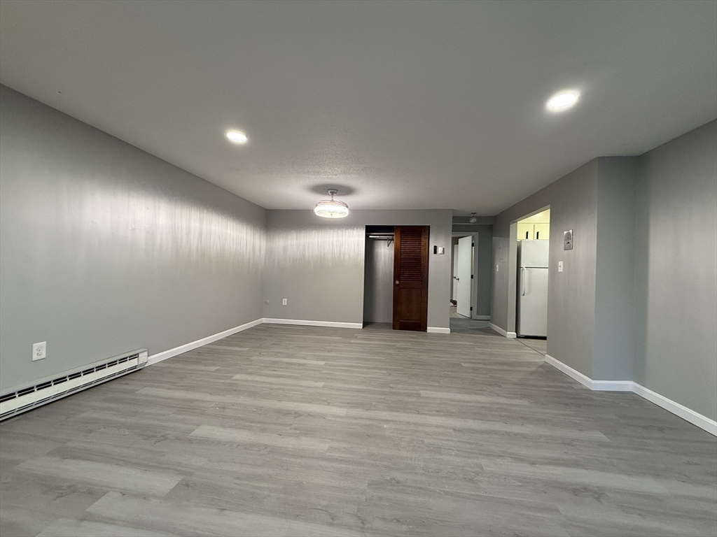 1186 Worcester Road, Unit 610 Framingham, MA 01702 - Photo 6 of 37 an empty room with wooden floor and windows