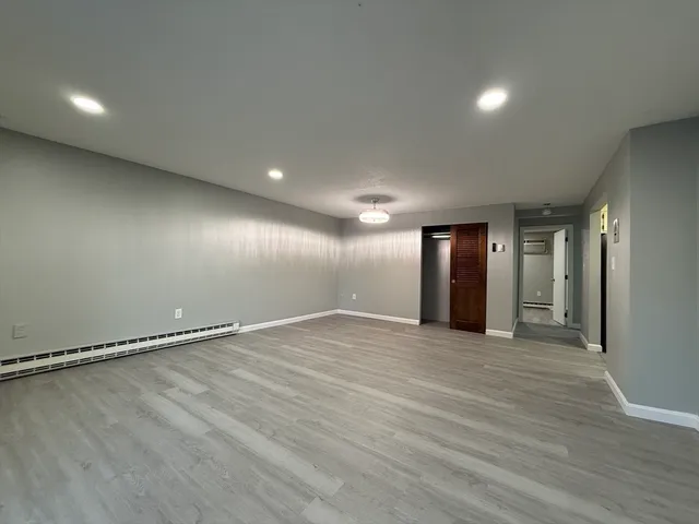 a view of an empty room with wooden floor