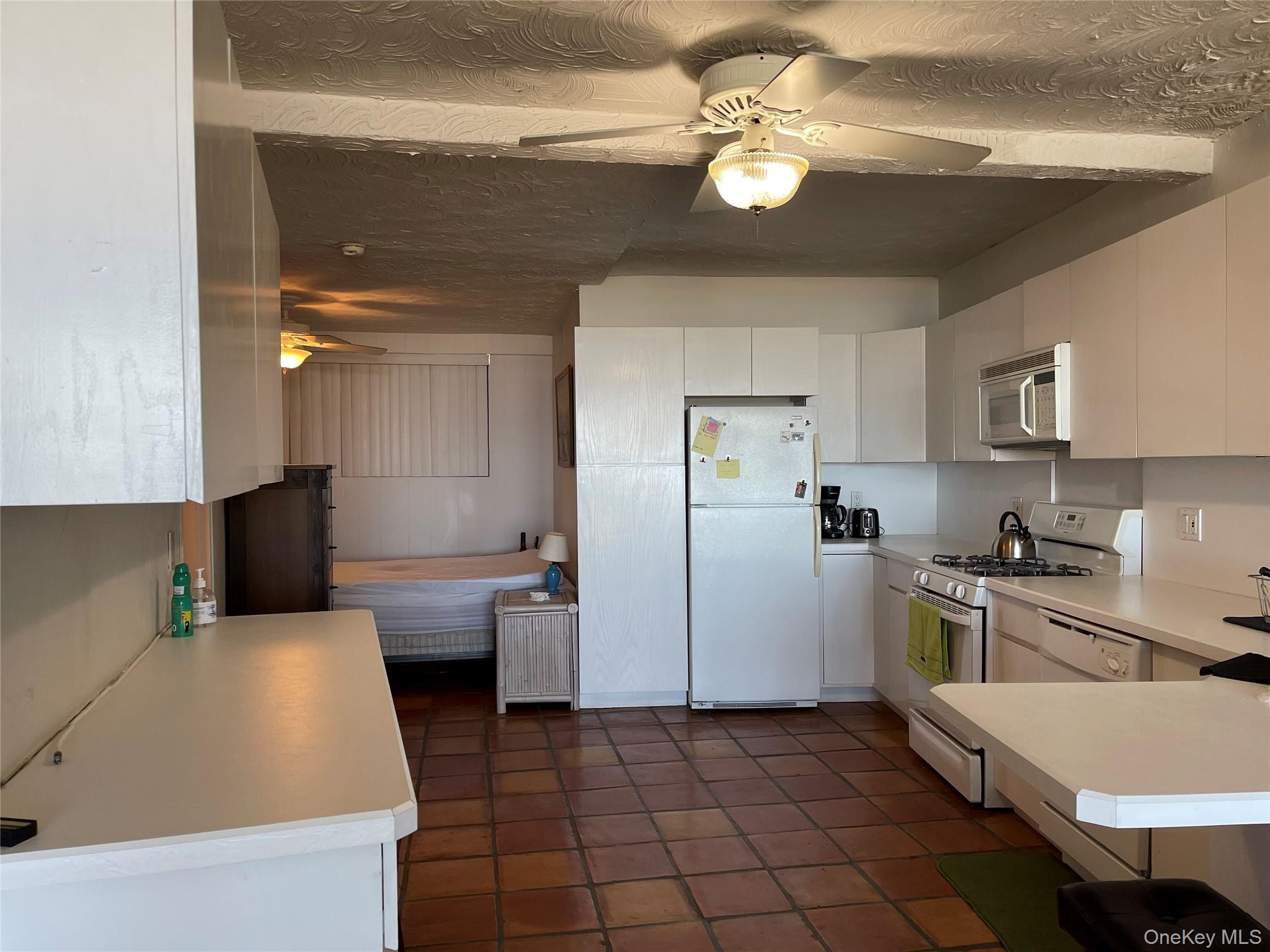 830 Shore Road, Unit 3E Long Beach, NY 11561 - Photo 10 of 13 a kitchen with a refrigerator a stove top oven a sink dishwasher and white cabinets