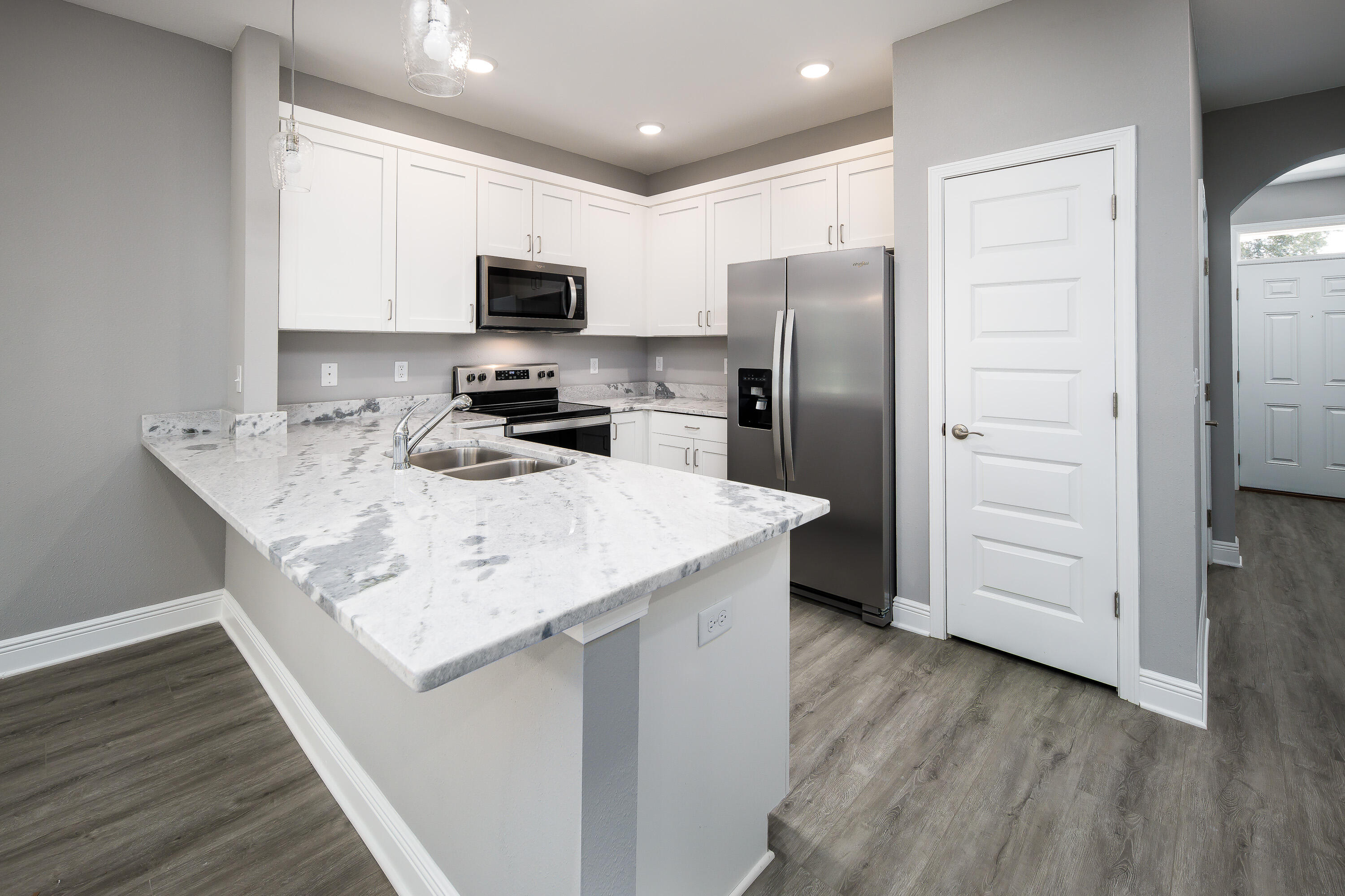 971 Skylark Road Mary Esther, FL 32569 - Photo 6 of 31 a kitchen with a refrigerator a microwave a sink and cabinets